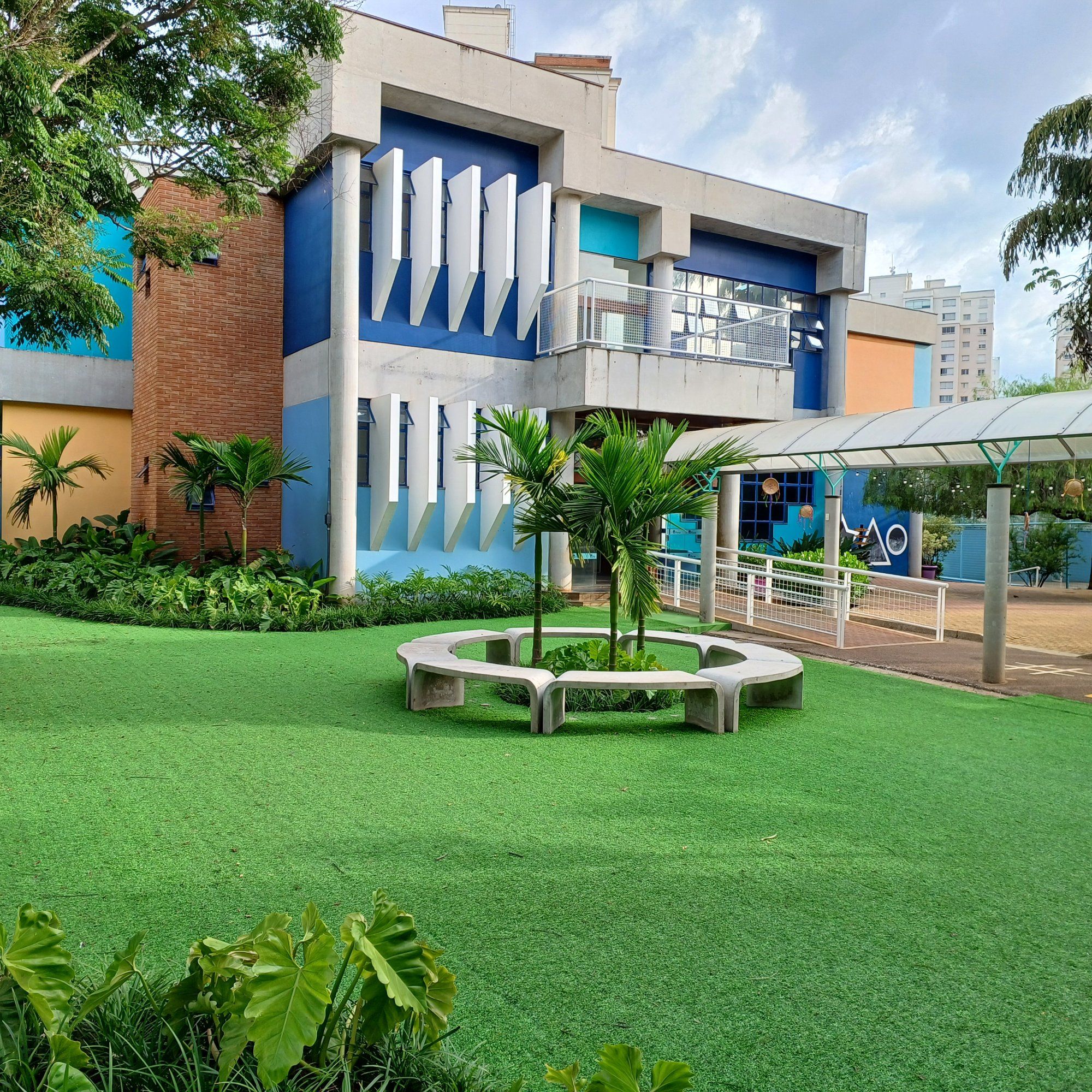 Pátio da escola com gramado e bancos